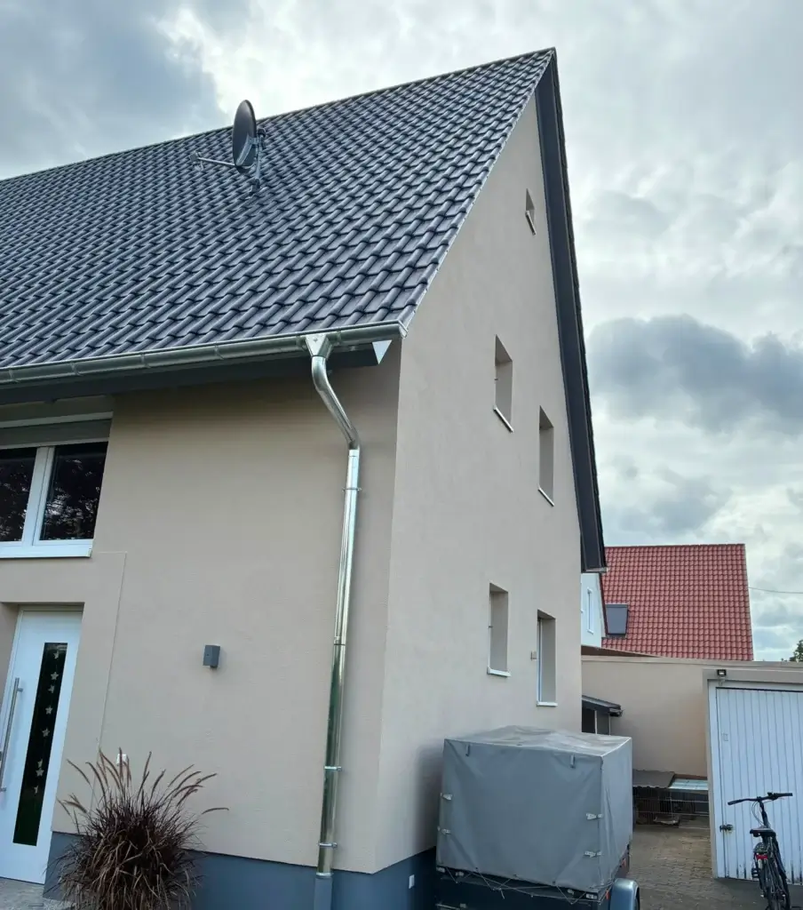 Wohnhaus mit grauem Dach und neuen Dachrinnen – Spenglerarbeiten