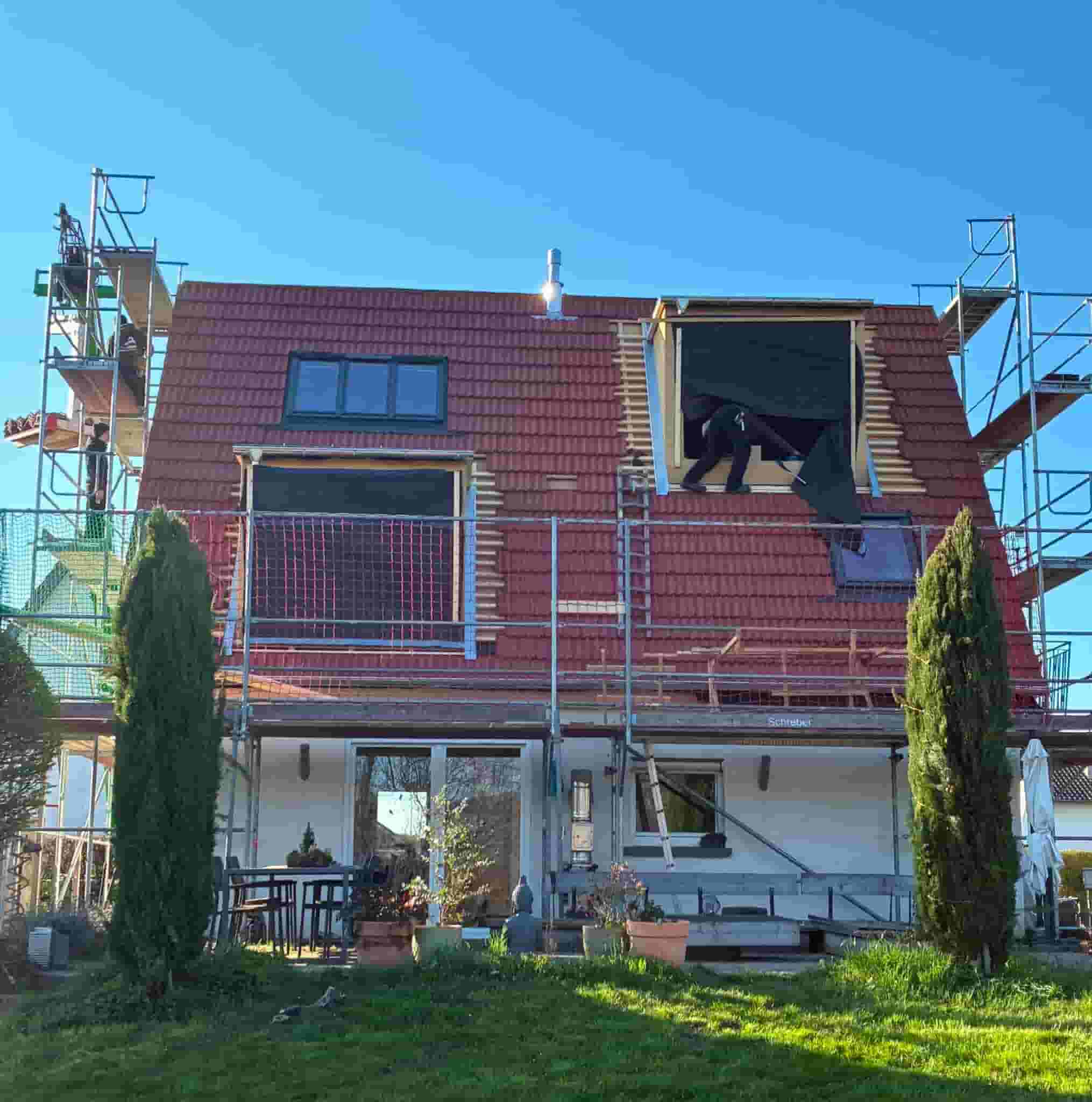 Wohnhaus mit neuer roter Dacheindeckung und Gerüst